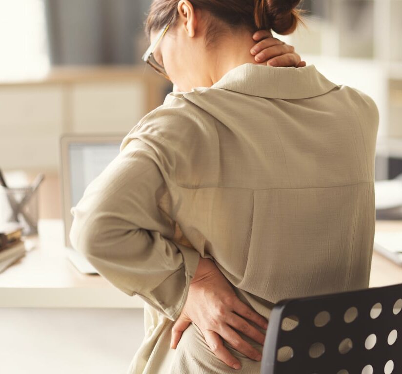 Business woman of pain in the back and neck